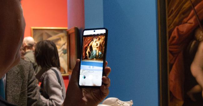 Fotografia: ktoś robi smartfonem zdjęcie marmurowej nagiej rzeźby w muzeum