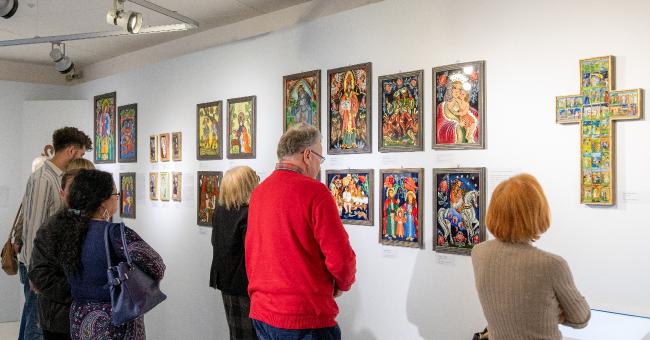 Fotografia ludzi oglądających kolorowe ikony i krzyże w galerii