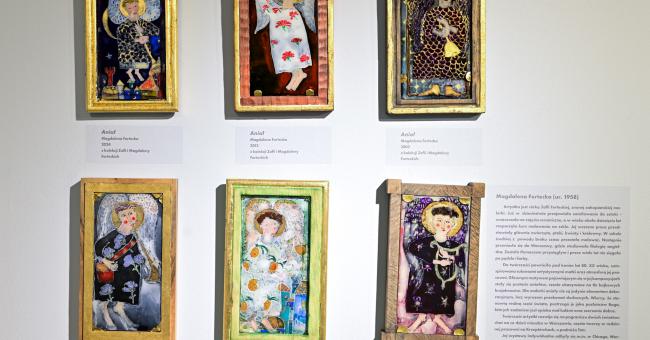 Sześć kolorowych, oprawionych malowideł na szkle z ludowymi scenami na białej ścianie