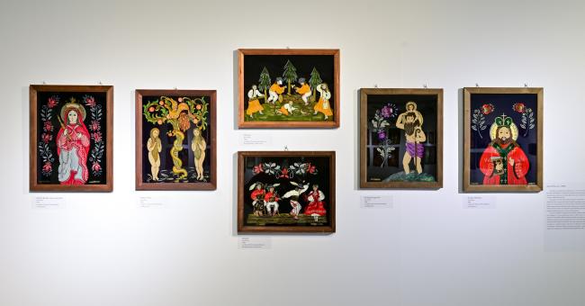 Fotografia wystawy: ściany galerii z sześcioma kolorowymi, ramowanymi obrazami ludowymi