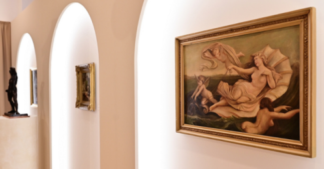 Wnętrze galerii muzealnej z obrazami.