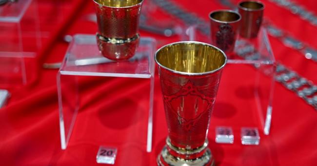 Fotografia: złote kielichy na czerwonym aksamicie w muzealnej witrynie