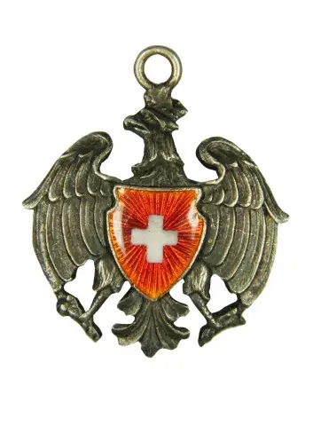 Metalowa zawieszka — orzeł z rozpostartymi skrzydłami i czerwonym herbem z białym krzyżem