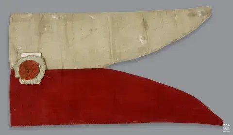 Nakładające się tkaniny na szarym tle: beżowa z czerwonym naszytym krążkiem i czerwona