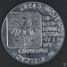 Fotografia srebrnego medalu z orłem państwowym i okrągłym napisem urzędowym