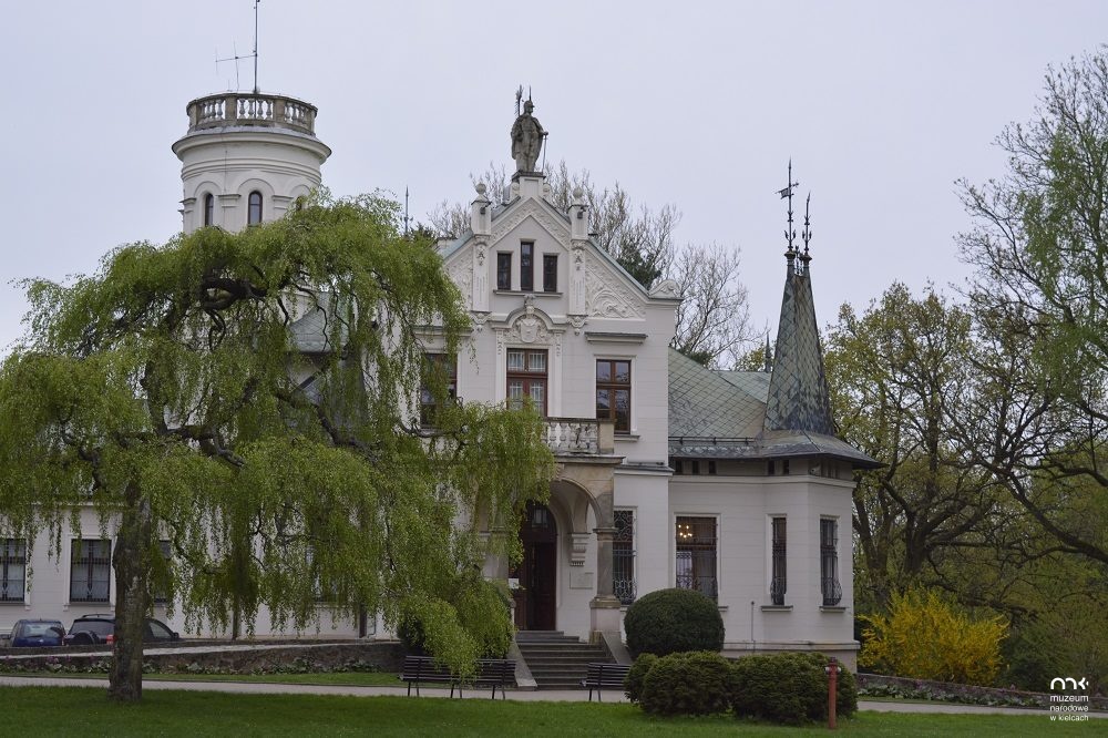 Pałacyk Henryka Sienkiewicza w Oblęgorku, widok od strony wejścia głównego, na zdjęciu pałacyk w otoczeniu drzew 